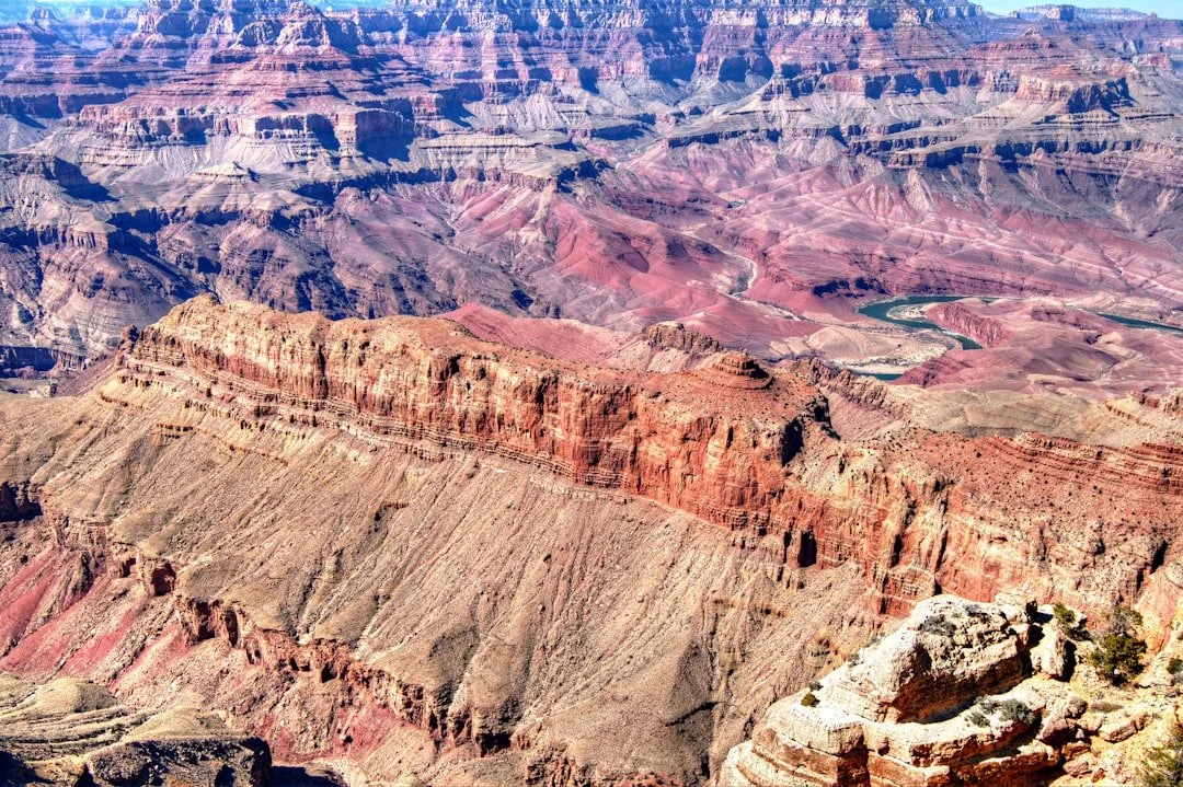 A deep red-rock canyon with a green river winding far below