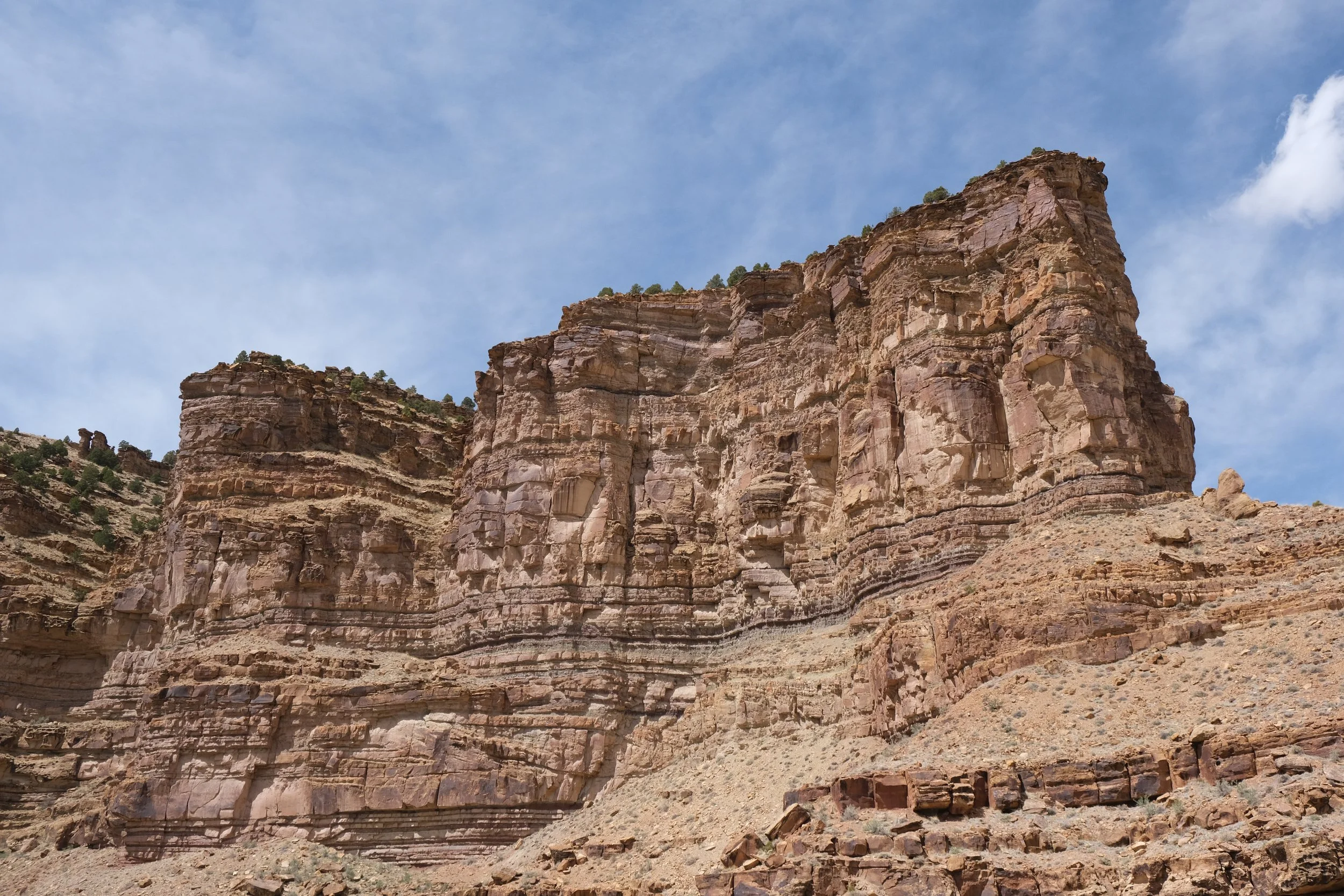 Layered red sandstone cliffs under a blue sky